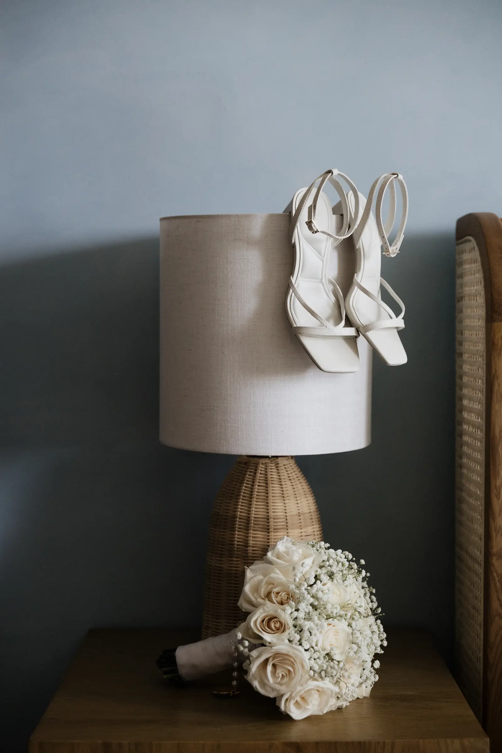 Bridal shoes and bouquet styled beside a table lamp