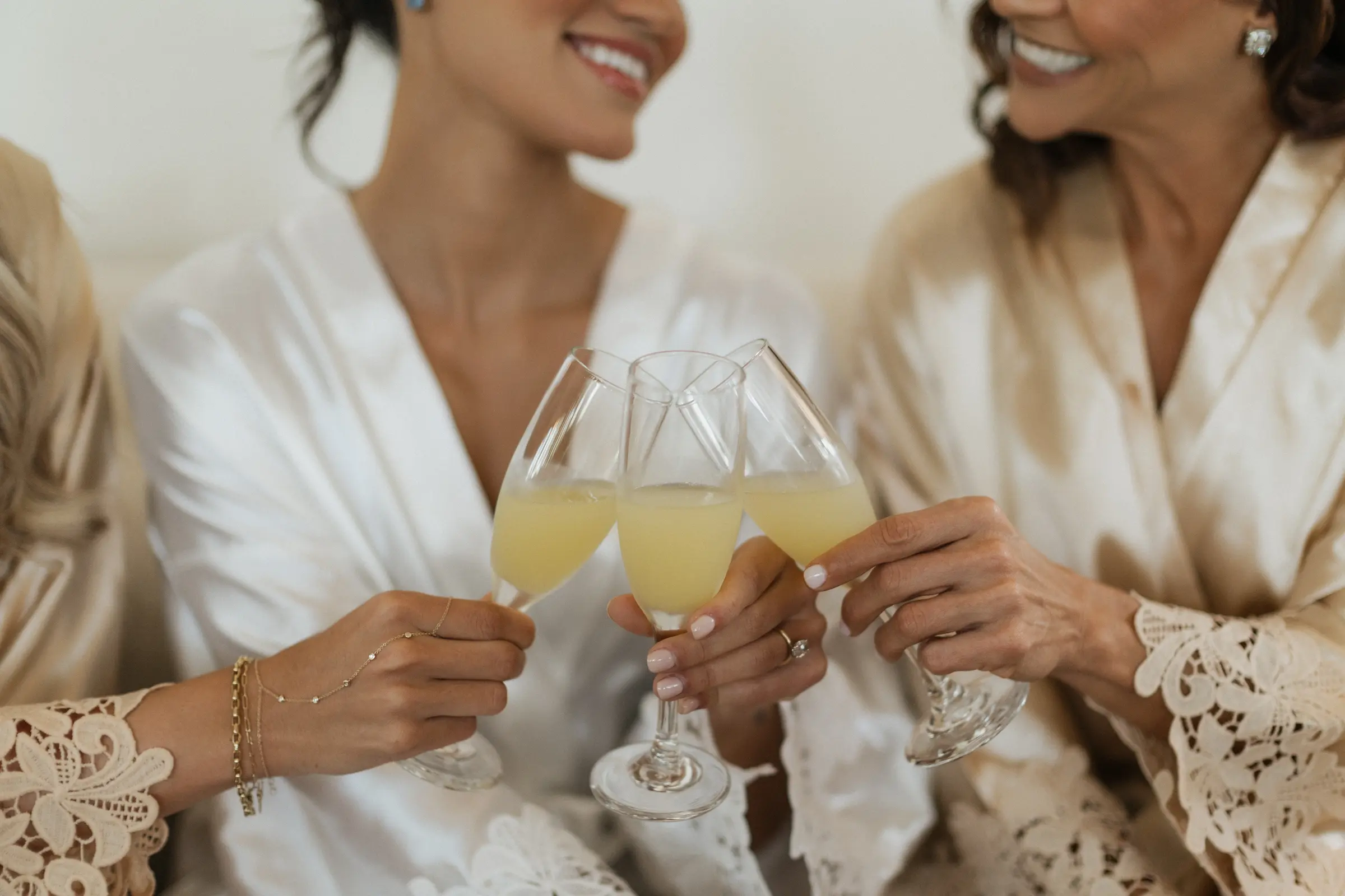 Bride and bridesmaids toasting with champagne in matching robes