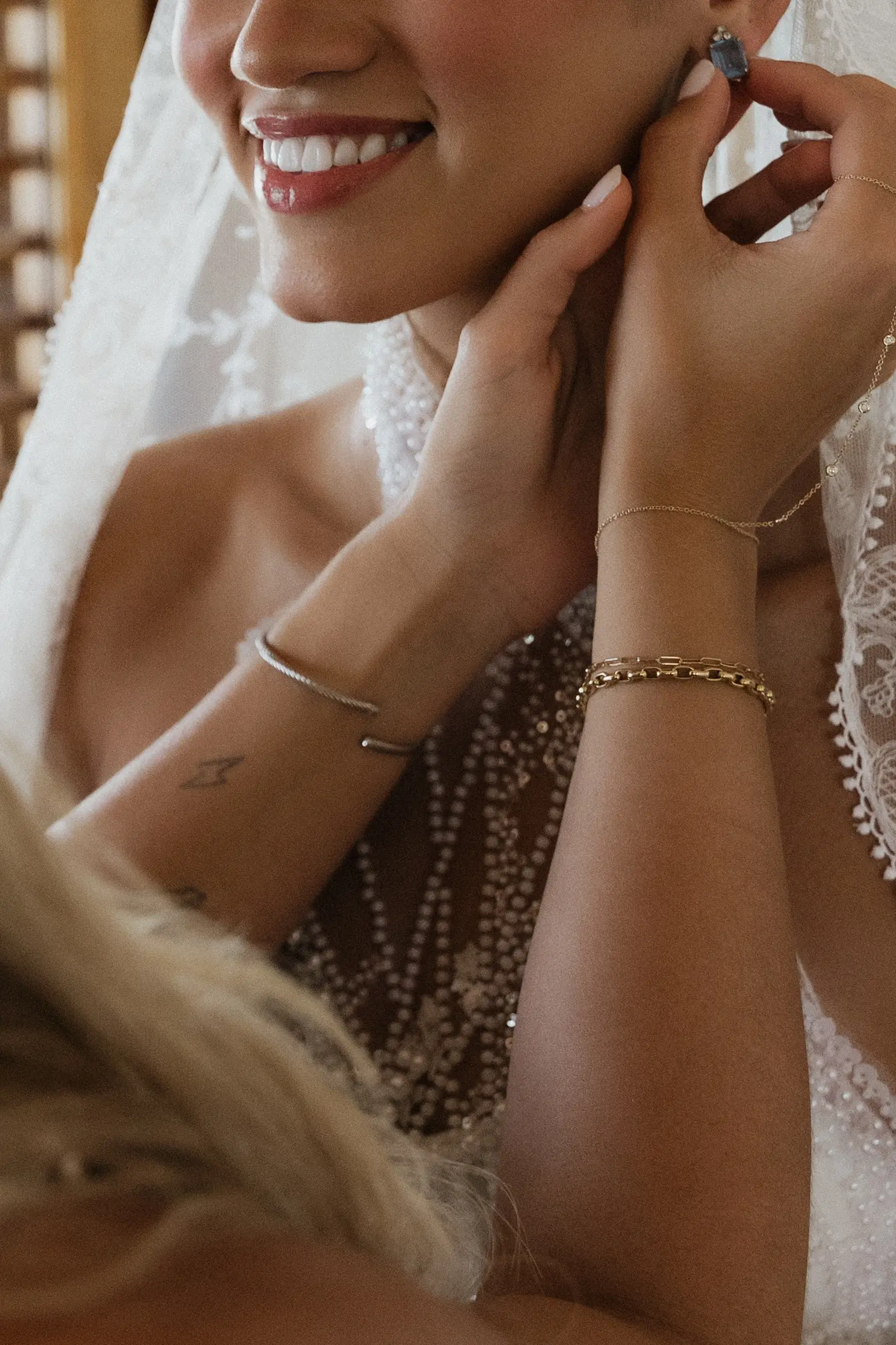 Bride laughing while fastening her earring, getting ready