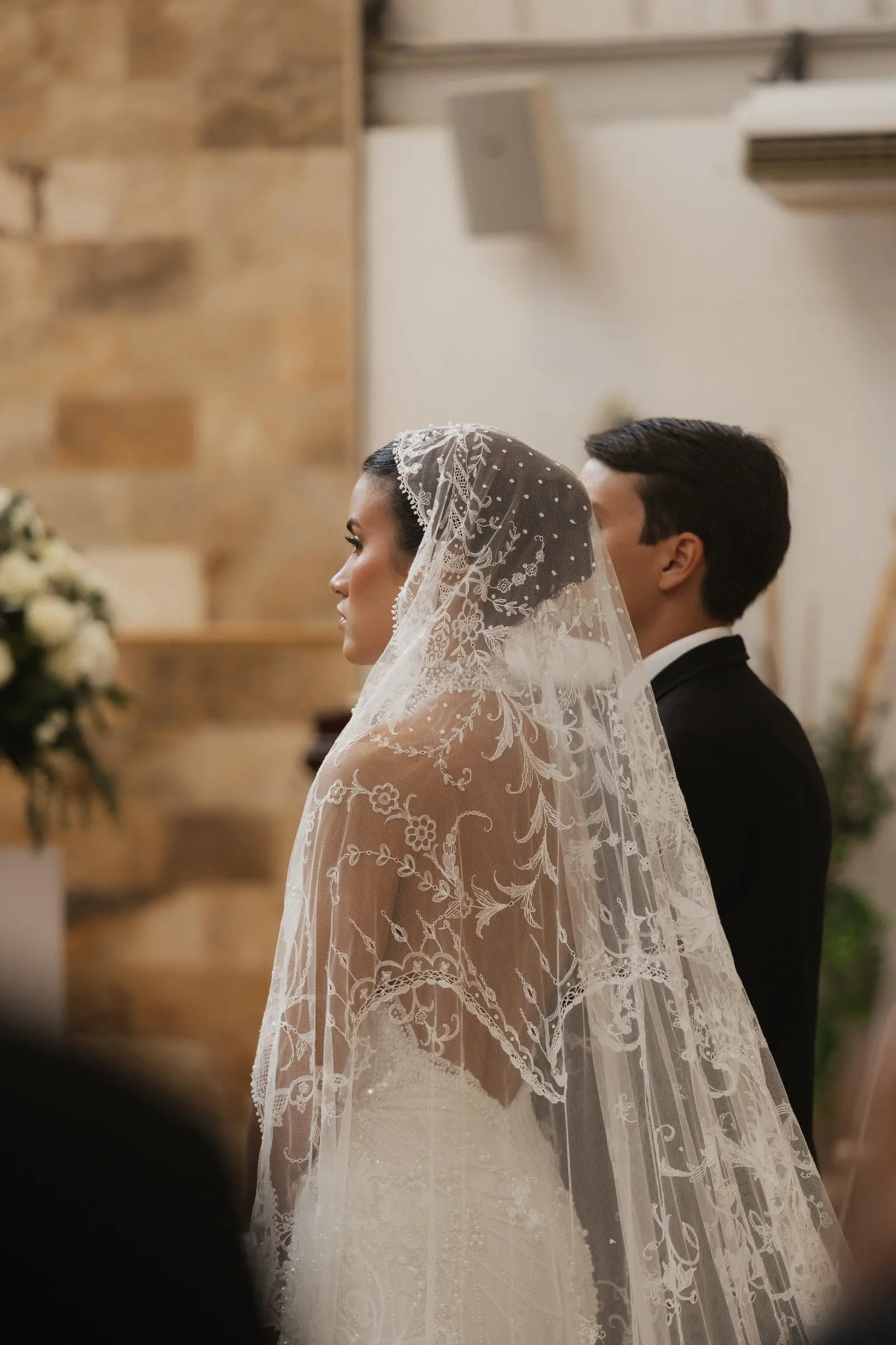 Bride wearing a veil during a traditional ceremony moment