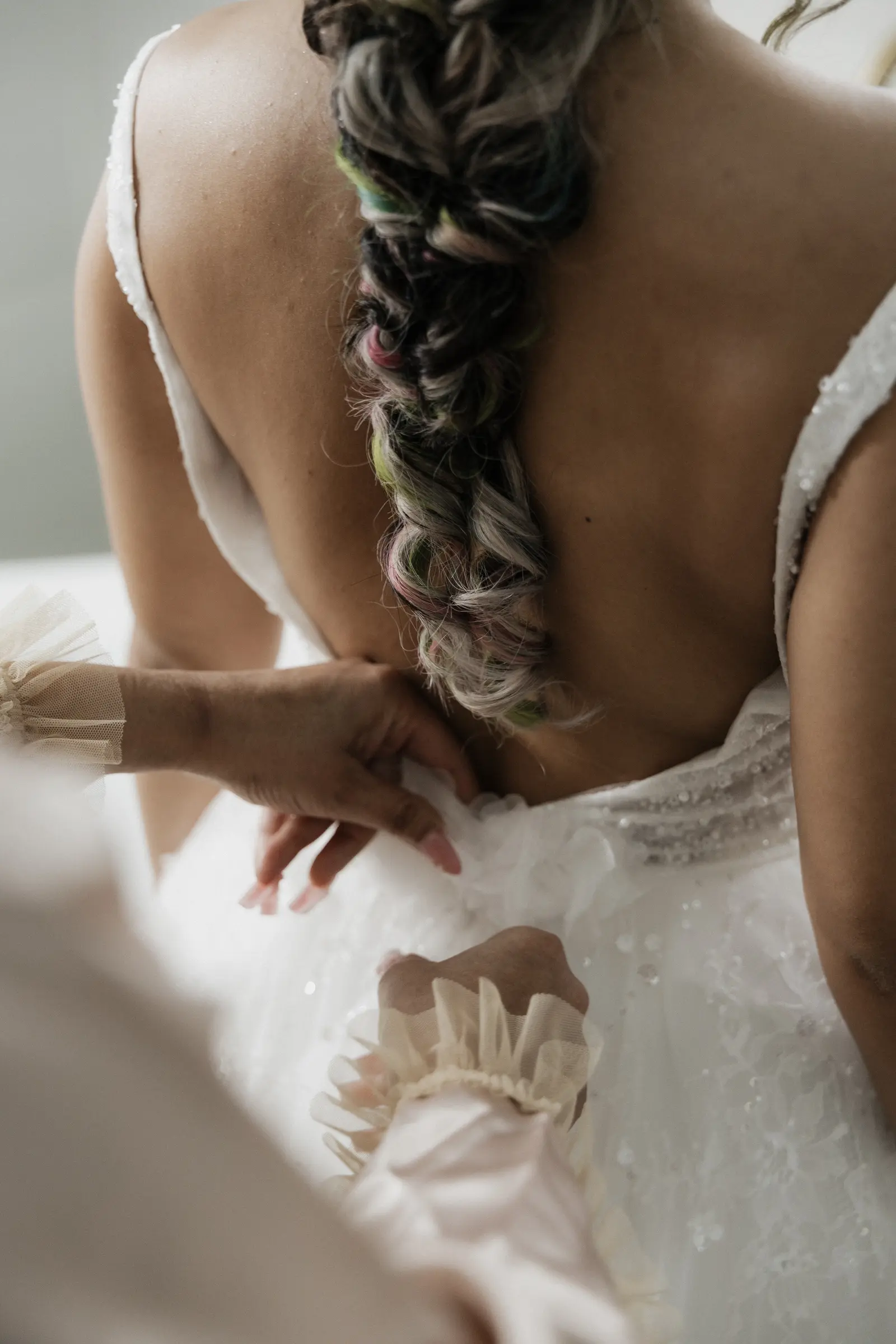 Close-up of the bride's braided hair and open-back dress