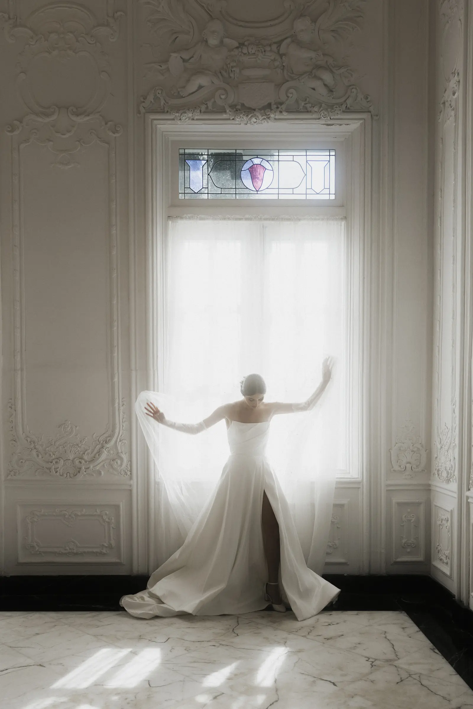 Bride standing alone in a sunlit doorway