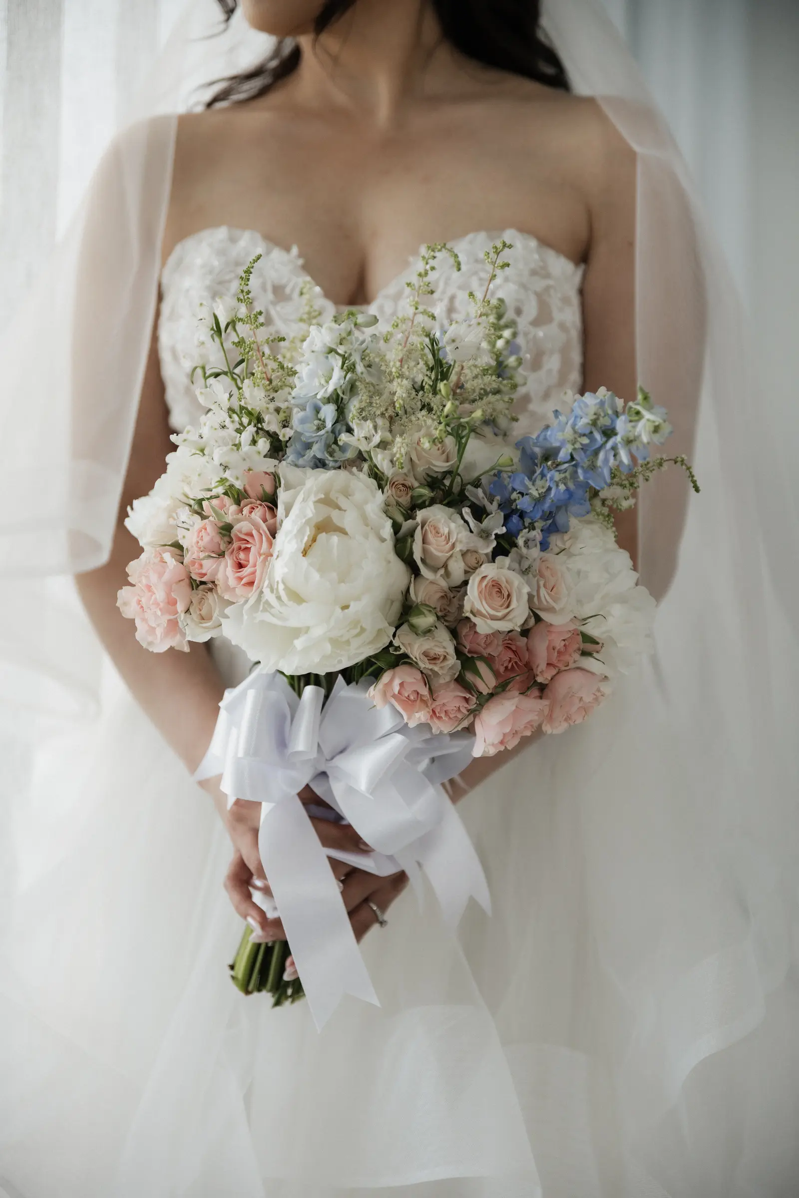 Bride holding her bouquet of white and blush florals