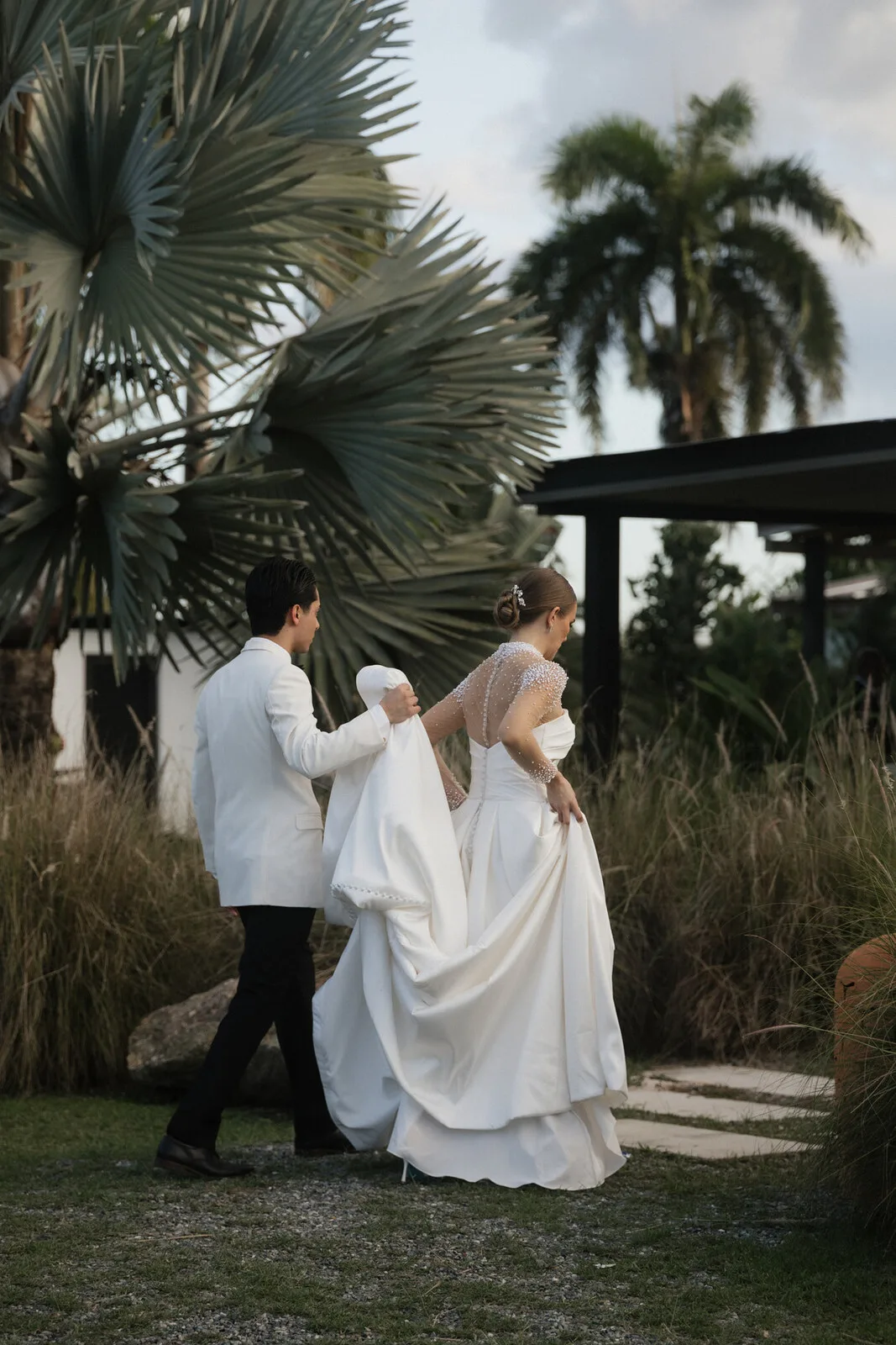 Officiant leading an outdoor wedding ceremony among palm trees