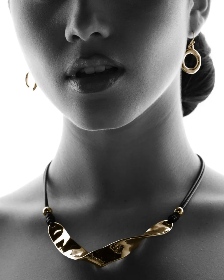 Black-and-white close-up portrait highlighting a woman's earring and necklace