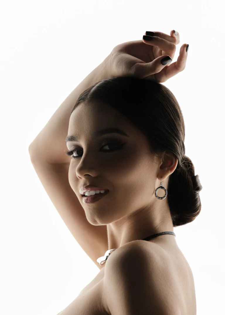 Black-and-white side-profile portrait of a woman with her arm raised elegantly