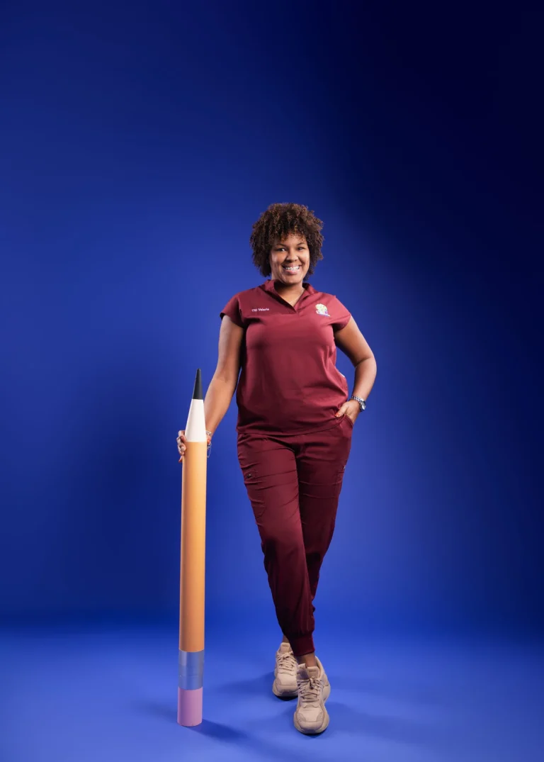 Woman in a maroon outfit standing against a deep blue studio backdrop