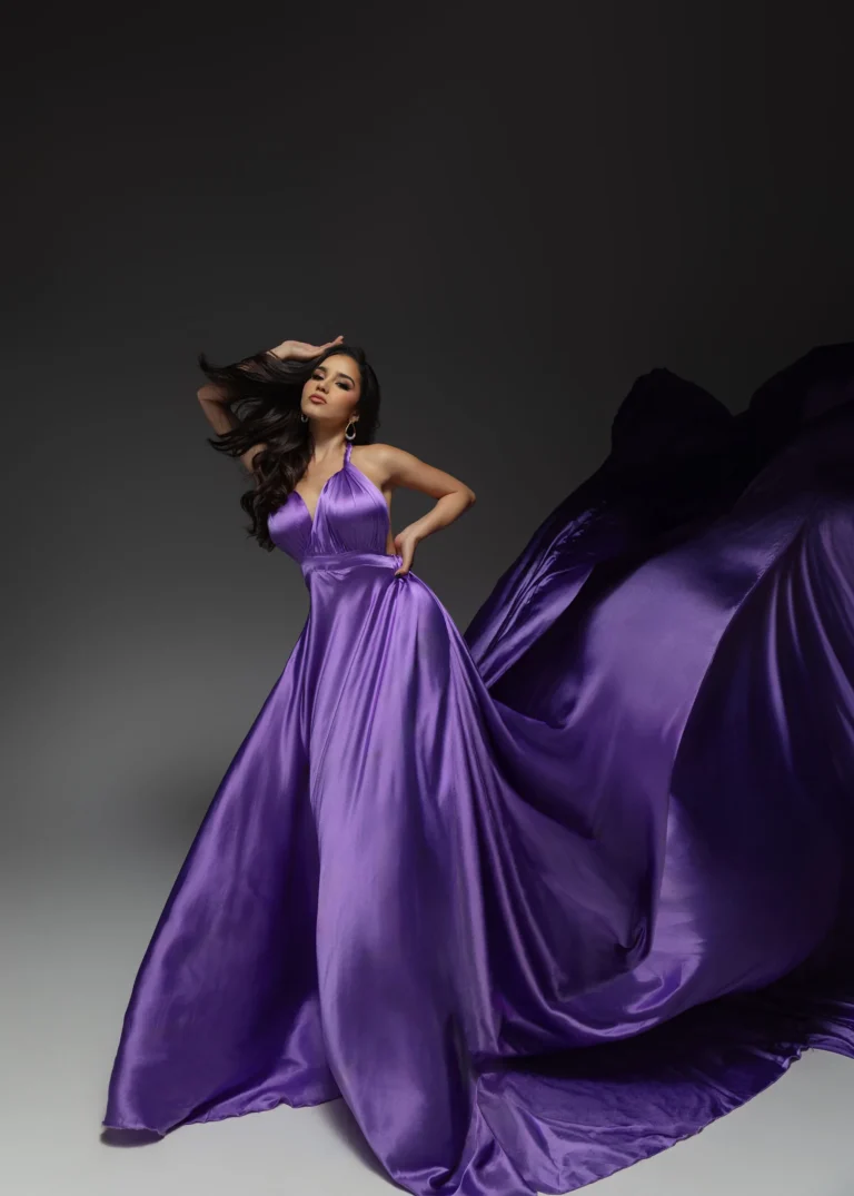 Woman in a flowing purple gown captured mid-movement in the studio
