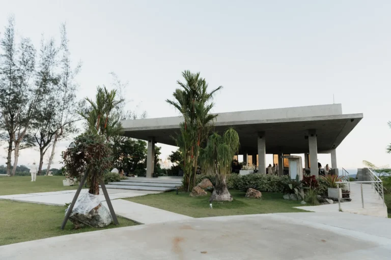 Modern concrete pavilion structure with a landscaped entrance walkway
